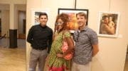 Artists Isaac Alcantar, Tokie Rome-Taylor, and Miles Davis in front of a painting by Alcantar