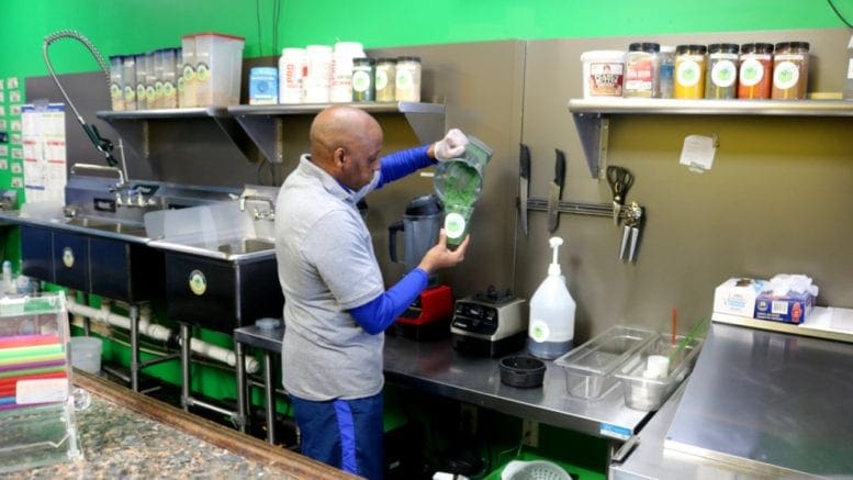 Ron Bolden, owner of Paradise Smoothie Juice Bar, mixes a Green Forest (photo by Larry Felton Johnson)