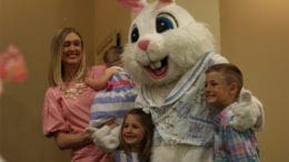 children and woman pose with person in bunny costume at the Bunny Breakfast