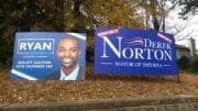 Campaign signs for Ryan Campbell and Derek Norton with the article about Smyrna mayor contributions for the December 3 runoff