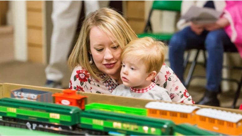 child looks over model railroad at museum