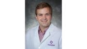 Dr. Jonathan Peeples, Wellstars Director of Telepsychiatry in lab coat with Wellstar logo