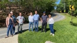 (From l-r) Nikkie Grzelka, John Huey, Ron Gaynor, Michael Thornton, Brad Grzelka, Eugene Williams and Diane Downs hope the most recent accident at this curve will bring much needed safety improvements to Pete Shaw Road.