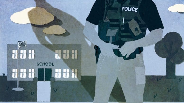Image of police officer in front of school building