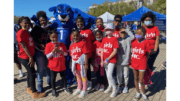 A group of girls in Girls Inc t-shirts with the Georgia State University mascot Pounce the panther