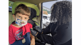 Boy with mask receiving vaccination)