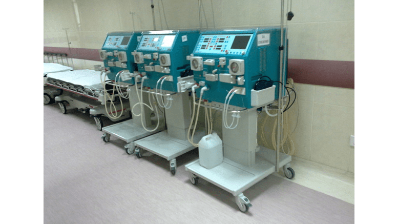 Three dialysis machines against a wall