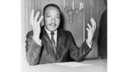 Martin Luther King Jr. with hand extended while speaking