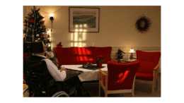 Man in Norwegian nursing home sitting in front of table by Christmas tree