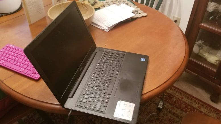 laptop and additional small keyboard on a dining room table