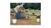 A woman cleans a headstone