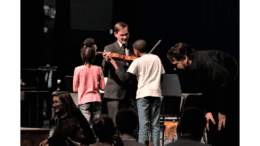 Children with GSO members, once holding a violin