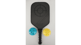 A pickleball paddle with two balls
