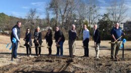 People lined up with shovels. From left, David Carl, President of Gay Construction; Holly Quinlan, CEO of Cobb Travel and Tourism; Councilmember Lynette Burnette; Councilmember Tracey Viars; Mike Everhart, amphitheater committee member; Councilmember Pat Ferris; City Manager Dr. Jeff Drobney; Mayor Derek Easterling; Parks and Recreation Director Steve Roberts