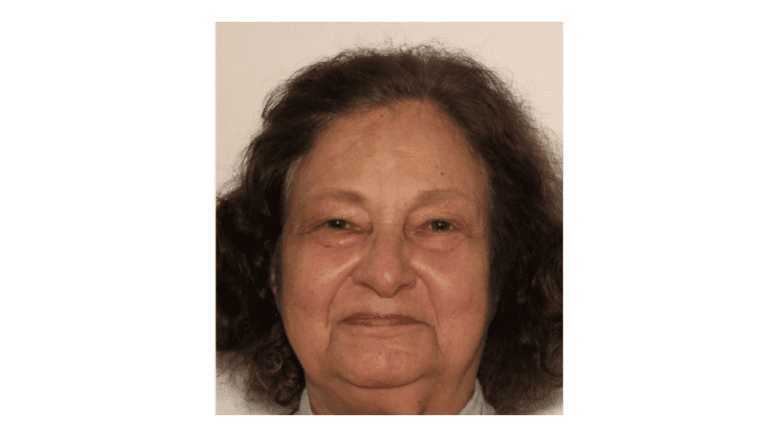 Headshot photo of a 79-year-old woman with dark medium-length hair
