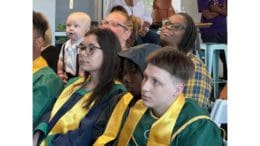 Several speakers offered advice to the grads in the audience. (Photo of three grads in audience)