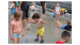 Child playing with stream of water in splash pad