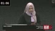 A mother with a hijab speaking at the Cobb school board
