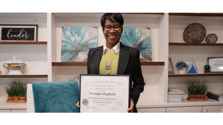 Commissioner Monique Sheffield holding certificate