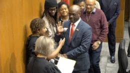 Newly elected Smryna Councilman Rickey Oglesby, Jr. at his swearing in ceremony speaks into a microphone held by a woman.