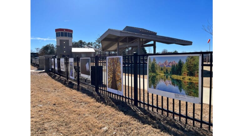 Art works hung along a metal fence at Aviation Park