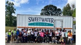 The South Cobb High School football team and other volunteers assemble for group shot in front of Sweetwater Mission